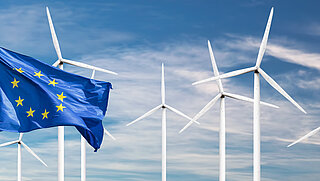 Europäische Flagge mit Windrädern im Hintergrund