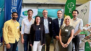 Menschengruppe an einem Messestand