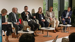 Podiumsteilnehmende auf der Bühne des KEI Podiums 2025