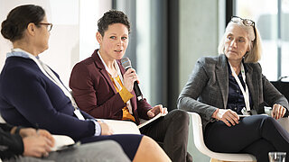 Diskussionsrunde auf der Bühne mit drei Frauen