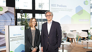 Constanze Haug und Jakob Flechtner lächelnd vor KEI Roll up und Bühne 