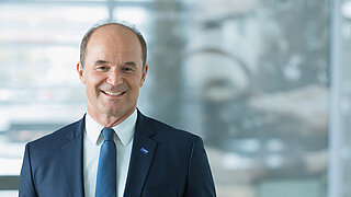 Ein Mann lacht freudig in die Kamera