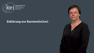 eine stehende Person, neben ihr an der Wand ist Text 