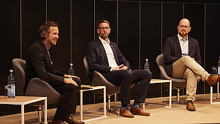 Dr. Kai Winkelmann, Koordinator Think Tank und Strategische Vorhaben im KEI, mit Dr. Michael Reitz von BASF und Tim Gnädig SCHOTT bei der Podiumsdiskussion „Perspektiven für die Dekarbonisierung" auf der Industrial Transformation Stage. Nahaufnahme der sitzenden Teilnehmer.