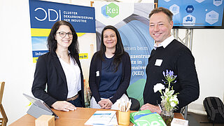Madeleine Henning-Wanieck, Monica Villanueva und Carsten Horch stehen am Messestand des KEI
