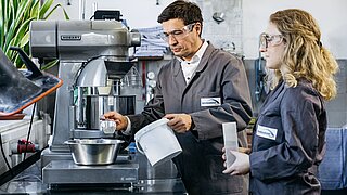 Zwei Personen experimentieren mit Zement