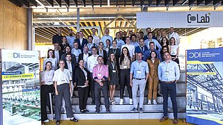 60 Teilnehmende der Veranstaltung CDI Summer Summit 2023 stehen auf einer Treppe für ein Gruppenfoto.